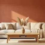 Salon lumineux aux murs terracotta et beige chaud avec canapé lin et table basse chêne