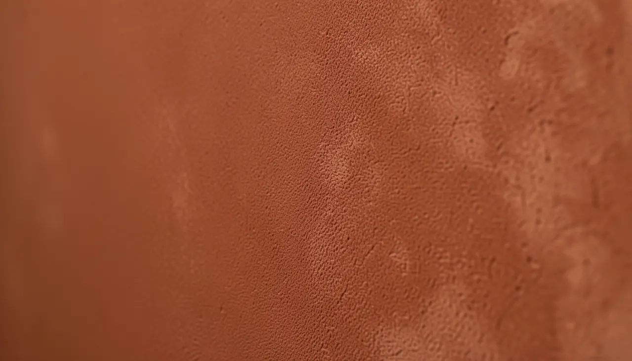 Détail texture peinture mate velours sur mur terracotta