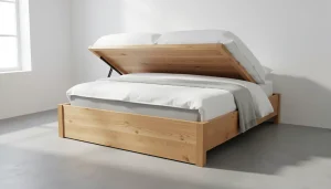Lit coffre en bois massif chêne clair dans une chambre épurée, sommier relevé montrant le volume de rangement